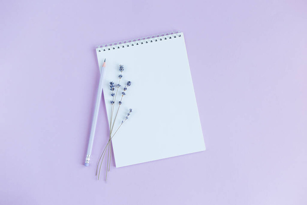 Notebook com página em branco, lápis e lavander em um fundo violeta. Deitado. Lugar para texto
.  - Foto, Imagem