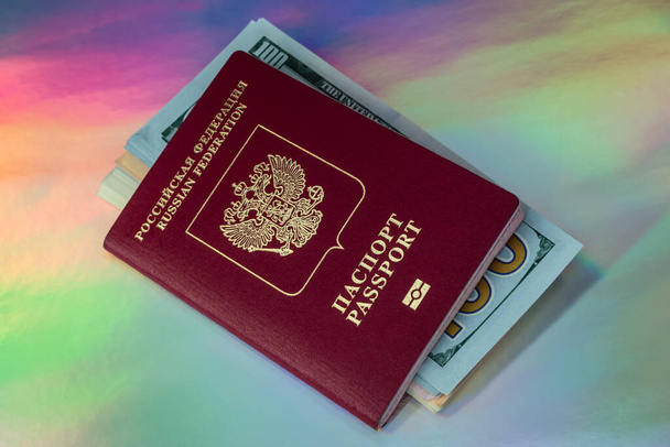 Russian passport on a multicolor holographic background. Concept: hope for a way out of the crisis, improvement of financial condition, travel around the world. - Photo, Image