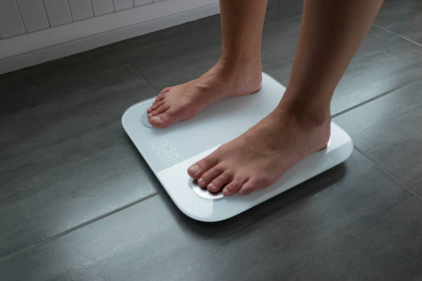 Tyttö tai poika asteikolla hallita painoa ja rasvaa ja terveyttä
 - Valokuva, kuva