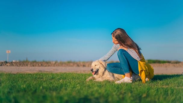 Young Child Girl Playing with Golden Retriever Dog Pet Outdoors Hugging Kissing - Photo, image