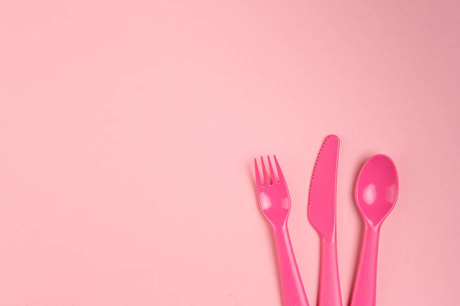 Vajilla de plástico para niños sobre fondo rosa
 - Foto, Imagen