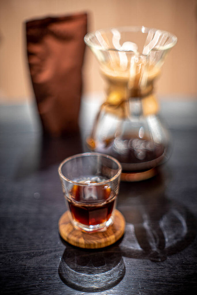 Black coffee brewing with kemex filter pour over glass house cafe sunlight table side view - Photo, image