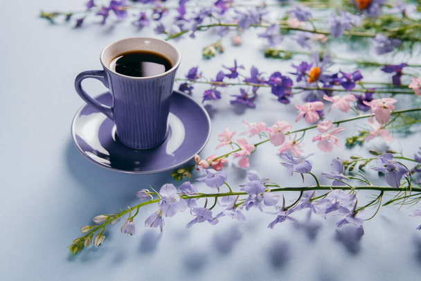 Summer subject photography. A cup of coffee and purple flowers - Foto, imagen