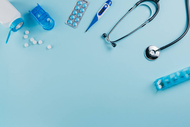 Equipo médico y pastillas sobre un fondo azul
 - Foto, Imagen