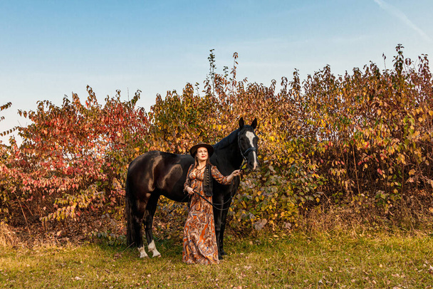 красива дівчина, жінка гуляє з конем осінньою дорогою крупним планом
 - Фото, зображення