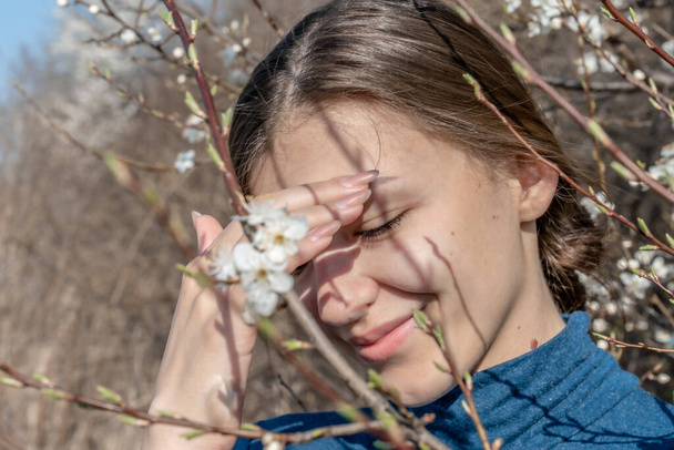 Portret van mooi jong meisje in de tuin van bloeiende bomen - Foto, afbeelding