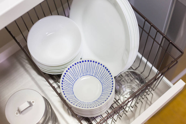 Keittiössä säilytettävät astiat, kuten kupit ja lautaset
 - Valokuva, kuva