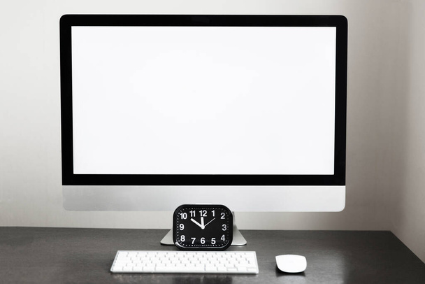 Werkplaats, klok en computer met toetsenbord op een donkere tafel in het kantoor. Ondernemingen en onderwijs - Foto, afbeelding