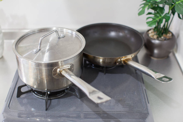 Herramientas de cocina como ollas y sartenes en la cocina estufa de gas
 - Foto, Imagen