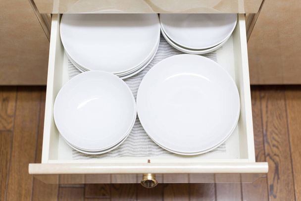 Keittiössä säilytettävät astiat, kuten kupit ja lautaset
 - Valokuva, kuva