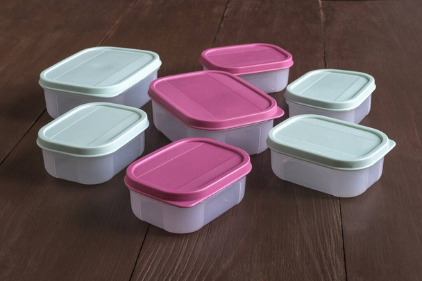 Plastic containers for transportation and storage food products laid out on a wooden table - Photo, Image