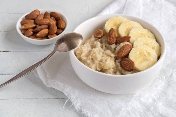 useful oatmeal porridge with almonds and bananas. - Photo, Image