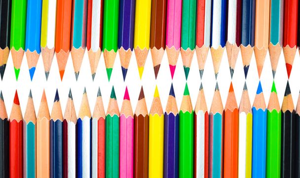Two row of different color pencil crayons placed on a white isolated background - Photo, Image