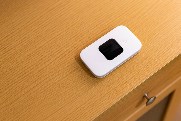 A small, portable WIFI router device placed inside a house - Photo, Image