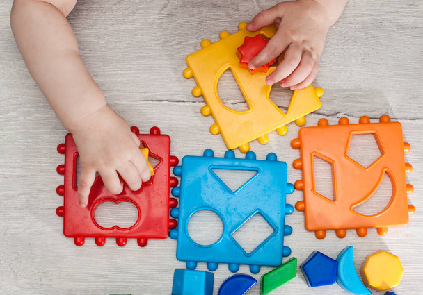 Lähikuva: Kädet pieni Montessori lapsi oppia koosta, tilaukset, lajittelu, järjestämällä mukana värikäs puinen aistiharkot. Opetuslelut, Kognitiiviset taidot, Montessori toiminta
. - Valokuva, kuva