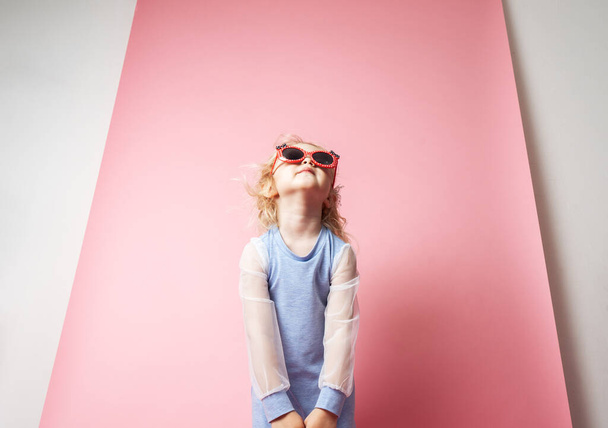 Little girl child in sunglasses with a pink redicle. - Φωτογραφία, εικόνα