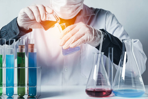 Chercheur avec tubes à essai chimiques de laboratoire en verre avec liquide pour le concept de recherche analytique, médicale, pharmaceutique et scientifique. - Photo, image