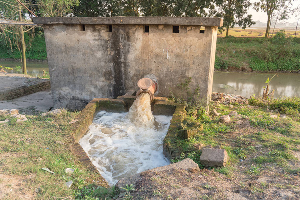 Typowy azjatycki system pompowania irygacyjnego z bąbelkami płynącymi na wodzie płynącej z rurociągu rurowego w Wietnamie - Zdjęcie, obraz