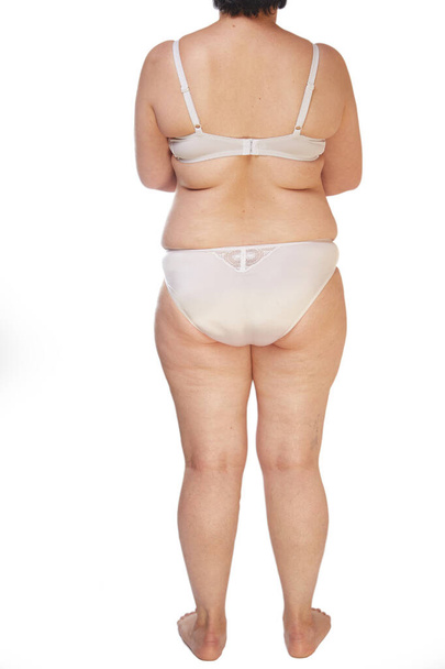ноги, сідниці і спина 40-річної жінки з розтяжками, целюліт і зайва вага на білому ізольованому фоні
 - Фото, зображення