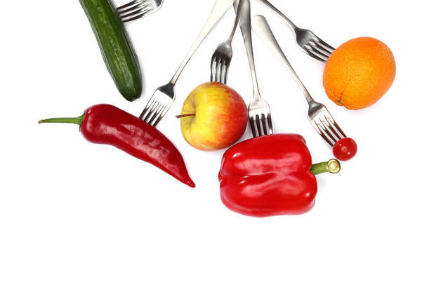 frische Kirschtomaten, Paprika, Gurken, Äpfel und Orangenfrüchte auf Gabeln auf weißem Hintergrund. Gesunde Ernährung und vegetarische Kost, Kochkonzept - Foto, Bild