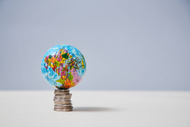 Stack of coins and globe on top mockup, copy space. Global money. International currency market. Global economy concept - Foto, Imagen