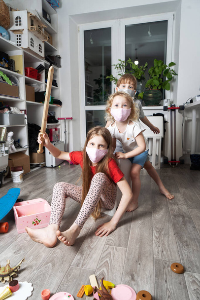 Stay home: Children in medical masks play with toys and ride in a white box. - 写真・画像