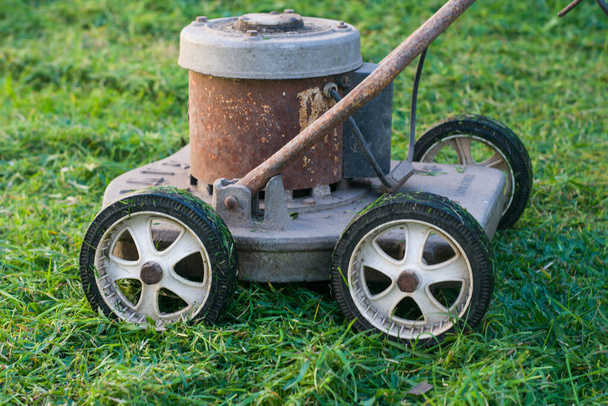 A old retro grass cutting machine. Old and rusty machine. - Photo, Image