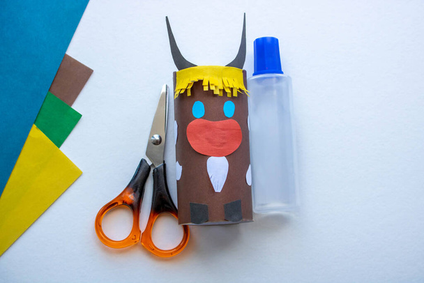 Step-by-step instructions. Step 5 Create a paper craft from a toilet sleeve. Brown bull. 2021.Chinese new year of the White Bull. Funny Halloween cute monster diy colored paper scissors glue. Children - Photo, Image