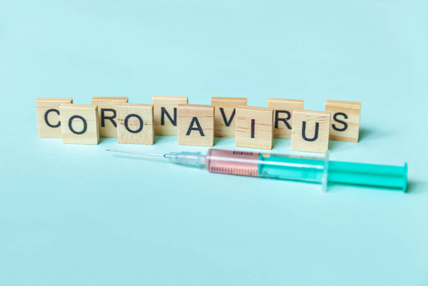 テキストフレーズ青いパステルの背景にコロナウイルスと注射器。新規コロナウイルス2019-nCoV MERS-Cov covid-19中東呼吸器症候群コロナウイルスワクチンコンセプト - 写真・画像