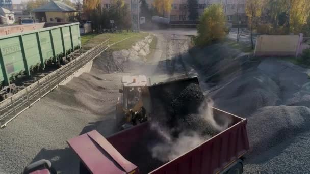 μπροστά φορτωτής φορτώνει χαλίκι σε χωματερή φορτηγό σώμα σε κόμβο logistics κατασκευή - Πλάνα, βίντεο