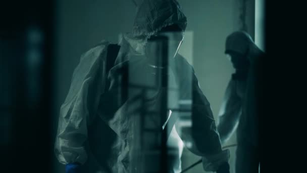 Inspetores sanitários filmados através de vidro durante a desinfecção. pandemia de coronavírus, prevenção de vírus, conceito COVID-19
. - Filmagem, Vídeo