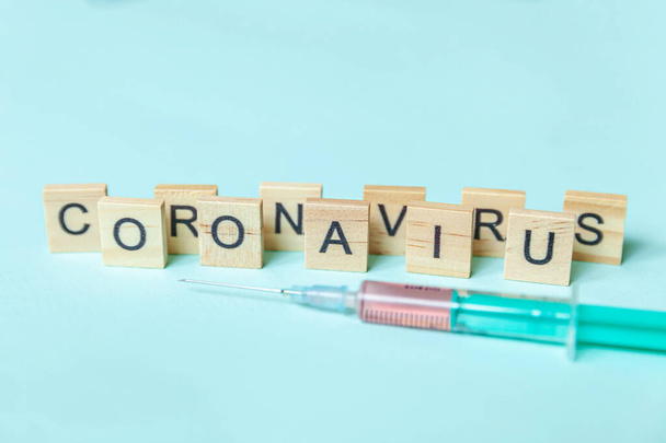 Tekstzin Coronavirus en spuit op blauwe pastelachtergrond. Novel coronavirus 2019-nCoV MERS-Cov covid-19 Midden-Oosten respiratoir syndroom coronavirus vaccin concept - Foto, afbeelding