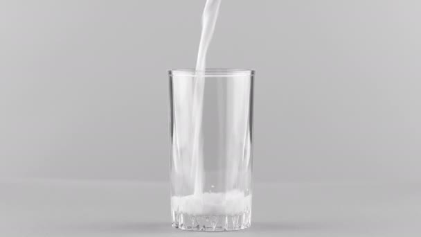Melk gieten in glas close-up geïsoleerd op lichtgrijze achtergrond - Video