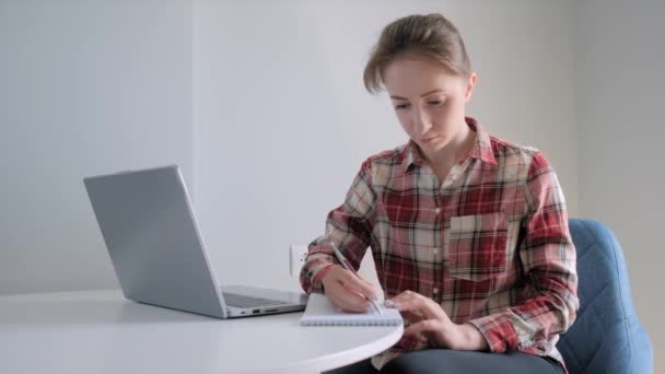 自宅で隔離中にノートパソコンを使用して赤い再生シャツの女性 – 自己分離 - 映像、動画