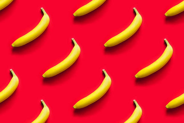 Pattern of yellow bananas on a red background. - Foto, Imagem