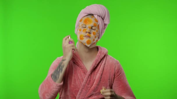 Transseksuele man in badjas met gezichtsmasker die parfum op de nek spuit. Chromatoetsen - Video