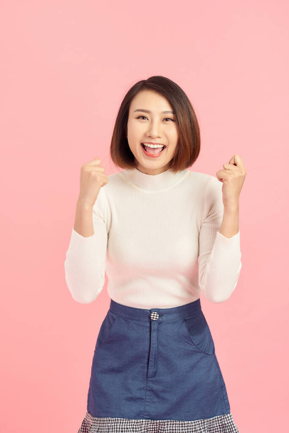 Portrait of an excited asian businesswoman looking at camera isolated over pink background - Fotografie, Obrázek