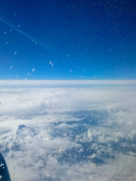 Кристали льоду на склі літака на великій висоті. Вид над хмарами
. - Фото, зображення