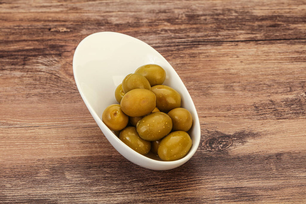 Zielone marynowane oliwki stos w misce - Zdjęcie, obraz