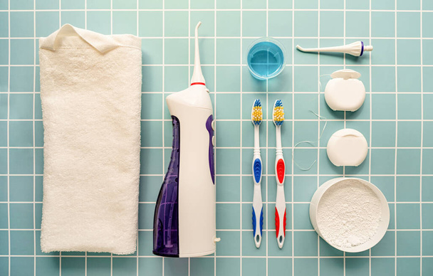 Zahnwerkzeuge, Zahnseide, Mundspülmaschine, Zahnbürsten und Zahnpuder Draufsicht auf blauem Hintergrund - Foto, Bild