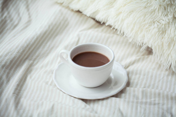 Egy csésze forró kakaó az ágyon. Karantén idő. A hajléktalanság. Hangulatos. - Fotó, kép