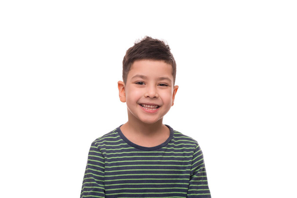 taille omhoog portret van een glimlachende jonge jongen dragen groen gestreept shirt tegen witte achtergrond  - Foto, afbeelding