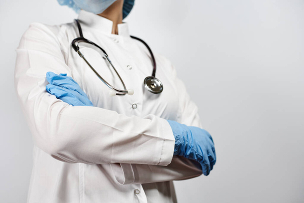 Vue recadrée d'une femme médecin posant avec stéthoscope en uniforme. Travailleur du système de santé en uniforme blanc et gants chirurgicaux. Médecine, Santé, concepts de consultation médicale en ligne
 - Photo, image