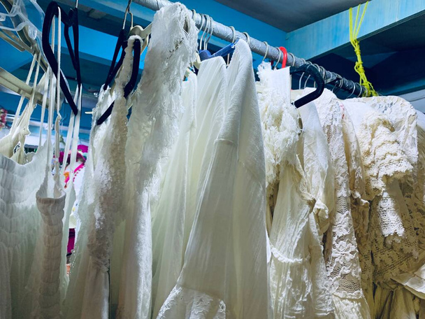 Witte kleding jurken op hangers, trouwwinkel - Foto, afbeelding