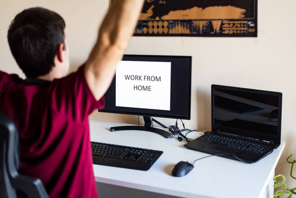 Мужчина растягивается во время работы из дома в импровизированном офисе в гостиной
 - Фото, изображение