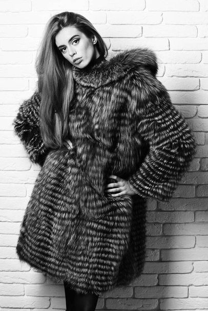 fashionable sexy woman in fur on brick wall studio background - Foto, afbeelding
