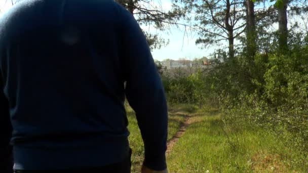  man in nature in a protective mask and gloves descends along a forest path The concept of man and in nature uses protection from the coronavirus pandemic. - Footage, Video