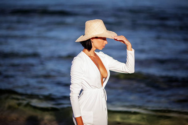 Beautiful woman by the ocean at sunset - Foto, Imagen