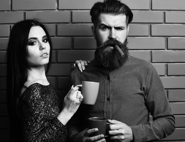 bearded man and pretty sexy woman with cigar, tea cups - Zdjęcie, obraz