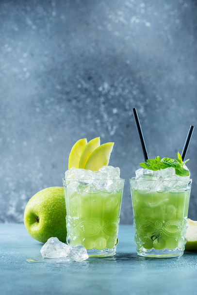 Green cocktail with ice and mint. Bar concept. Apple mojito with mint and ice on the blue background, selective focus image - Foto, Imagen